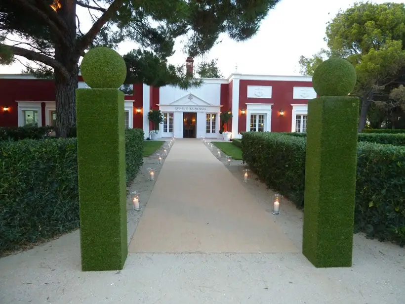 El paseo de entrada entre dos columnas de boj, con la casa al fondo