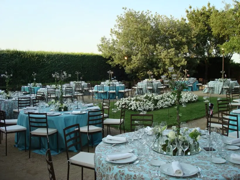 Cena al aire libre en el jardín, con manteles verdes y flores blancas